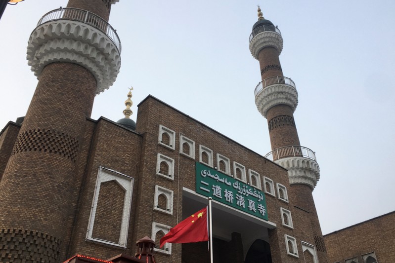 FILE PHOTO: The Chinese national flag flies outside the mosque at the Xinjiang International Grand Bazar during a government organised trip in Urumqi
