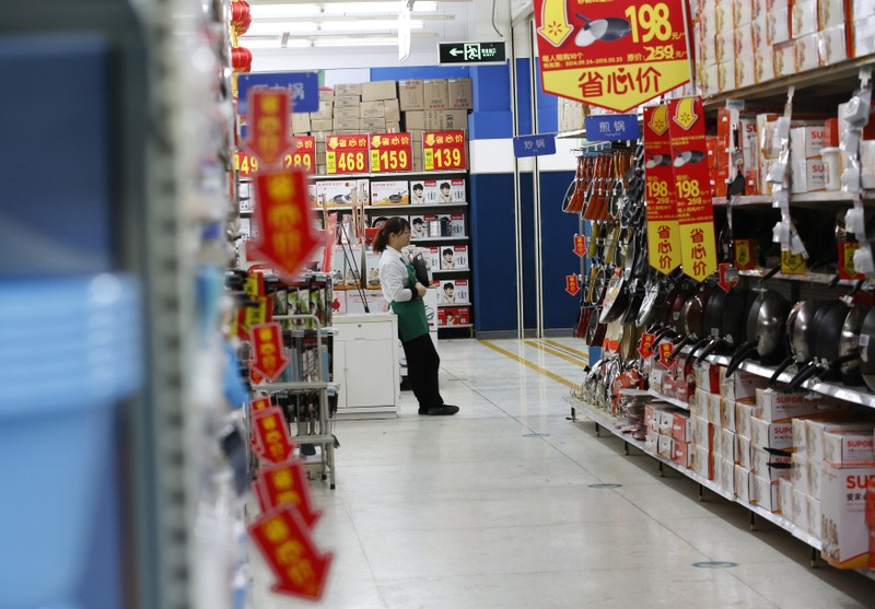 A sales promoter waits for customers at a discount department store in Beijing