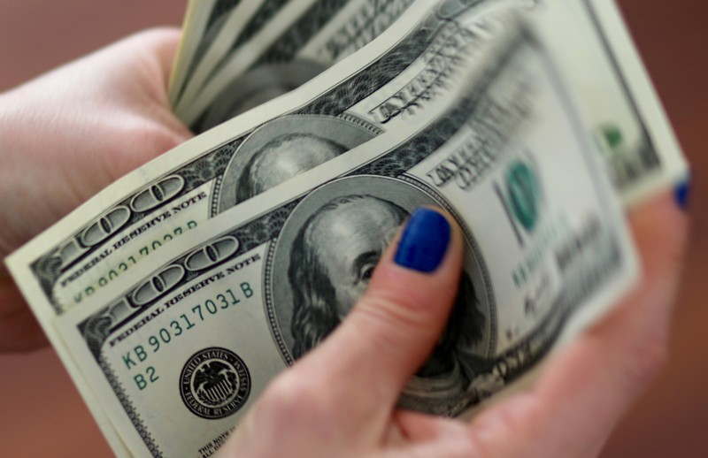 FILE PHOTO - A woman counts U.S. dollar bills at her home in Buenos Aires