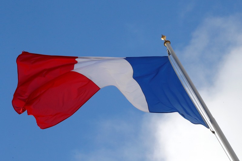 A French flag flutters in the sky over the Elysee Palace in Paris