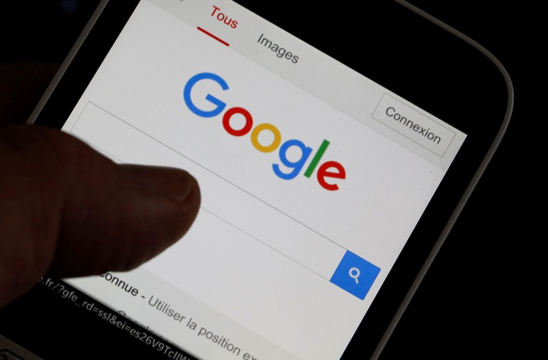A man holds his smartphone which displays the Google home page, in this picture illustration taken in Bordeaux, Southwestern France