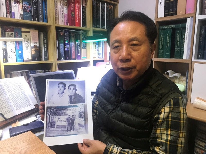 Ahn Yong-soo, whose brother was a South Korean prisoner of war captured by communist Vietnamese during the Vietnam War and sold to North Korean military officers, poses for photographs with a picture of his brother, at his home in Seoul, South Korea