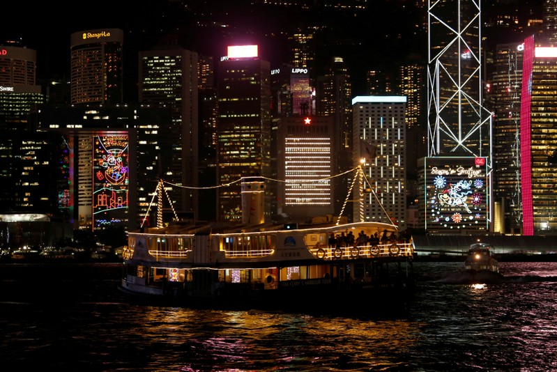 FILE PHOTO - A ferry sails past commercial buildings with Christmas decorations in Hong Kong