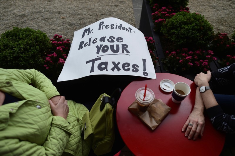 Demonstrators have coffee after a protest march in response to President Donald Trump's refusal to make his tax returns public in Philadelphia, Pennsylvania