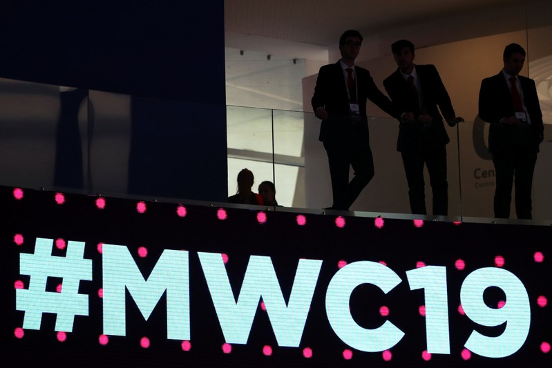 Men stand over a sign at the Mobile World Congress in Barcelona