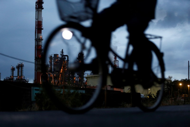 FILE PHOTO - A bicycle rider rides past a factory at Keihin industrial zone in Kawasaki