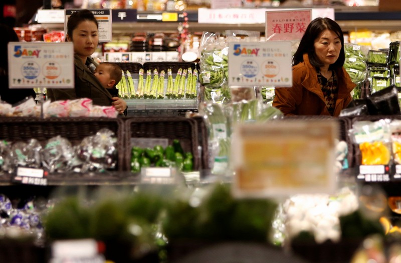 FILE PHOTO - Shoppers browse vegetables at a supermarket in Chiba