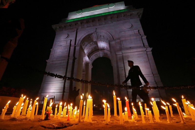 A soldier walks during a candle light vigil to pay tribute to CRPF personnel who were killed after a suicide bomber rammed a car into the bus carrying them in south Kashmir on Thursday, in front of India Gate war memorial in New Delhi