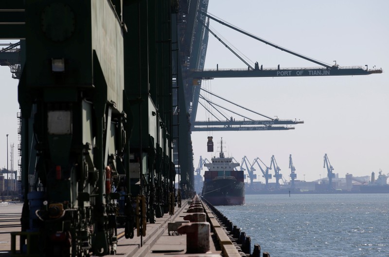 A container is carried away from a cargo ship at Tianjin Port