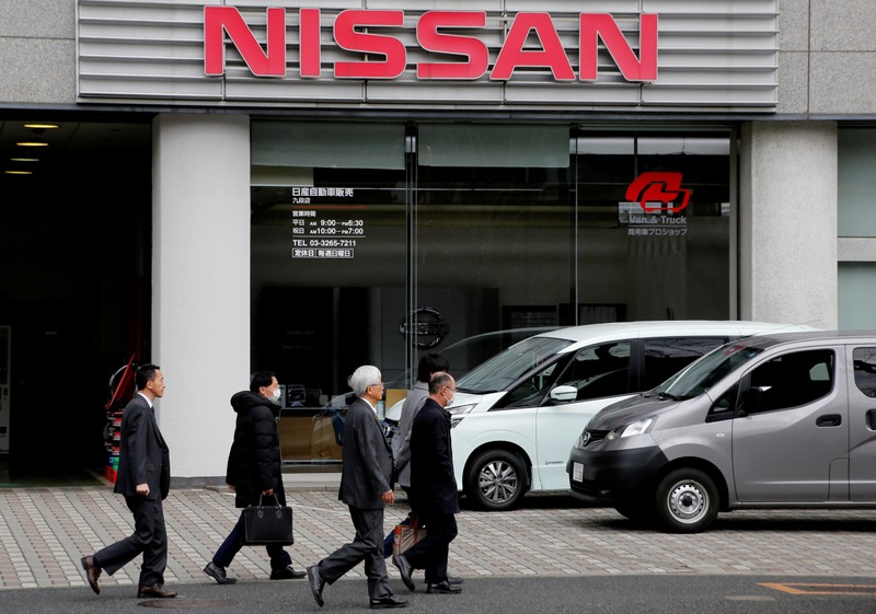People walk past a dealer shop of Nissan Motor Co. in Tokyo