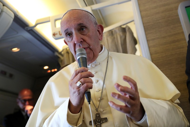 Pope Francis speaks to reporters aboard a plane on the way to Abu Dhabi