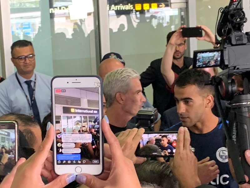 Hakeem al-Araibi, a refugee Bahraini footballer who was released from a Thai prison, is seen with Craig Foster as he arrives at the airport in Melbourne