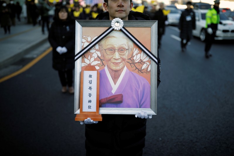 People march during a funeral of a former South Korean 