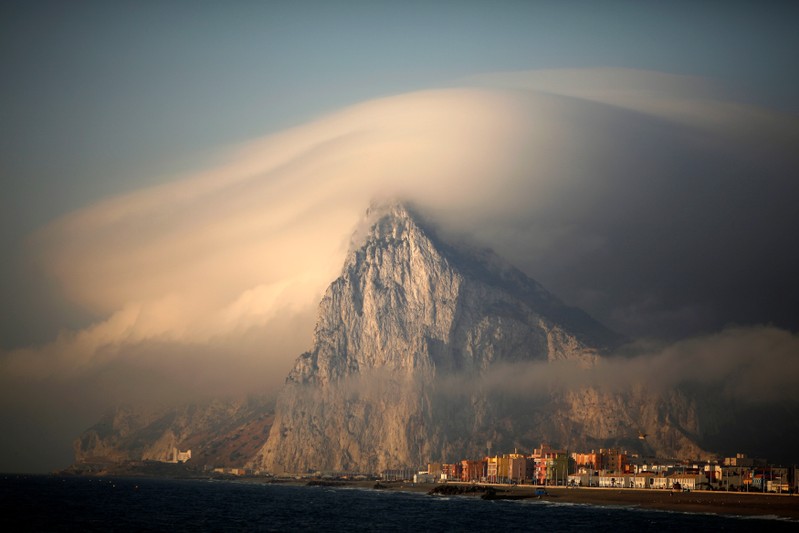 FILE PHOTO: Cloud partially covers Rock of the British territory of Gibraltar at sunrise before Spanish fishermen take part in a protest in Algeciras bay