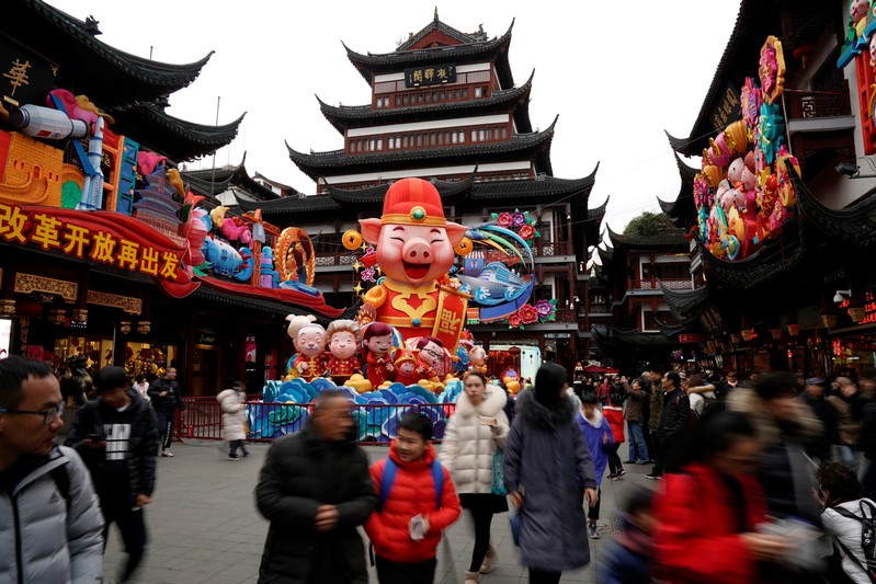 People walk by a giant decoration in the shape of a pig ahead of the upcoming Chinese Lunar New Year in Yu Yuan Garden in Shanghai