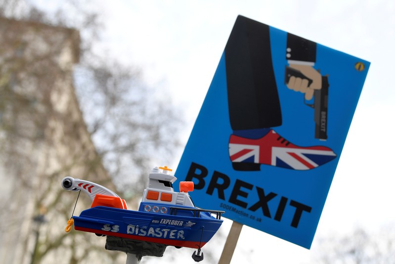 FILE PHOTO: Anti-Brexit protesters hold up a sign and a model prop boat outside Downing Street in London