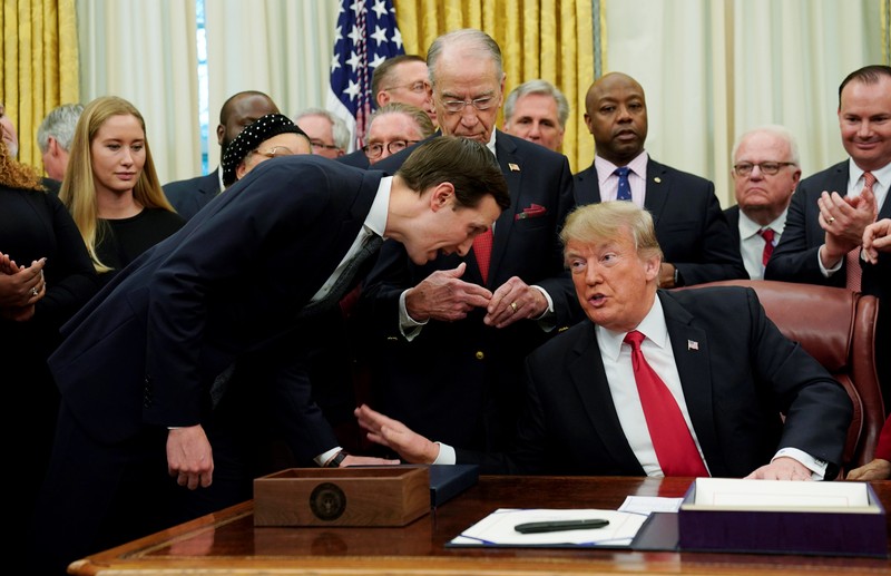 FILE PHOTO: White House advisor Kushner speaks with U.S. President Trump during bill signing ceremony at White House in Washington