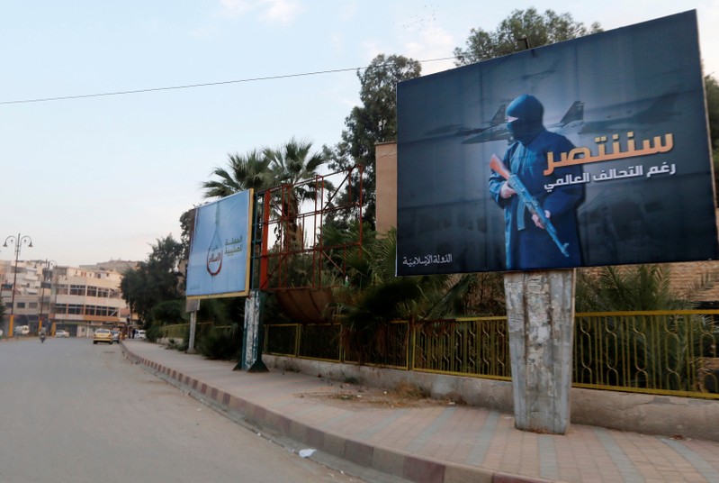 FILE PHOTO : Islamic State billboards are seen along a street in Raqqa