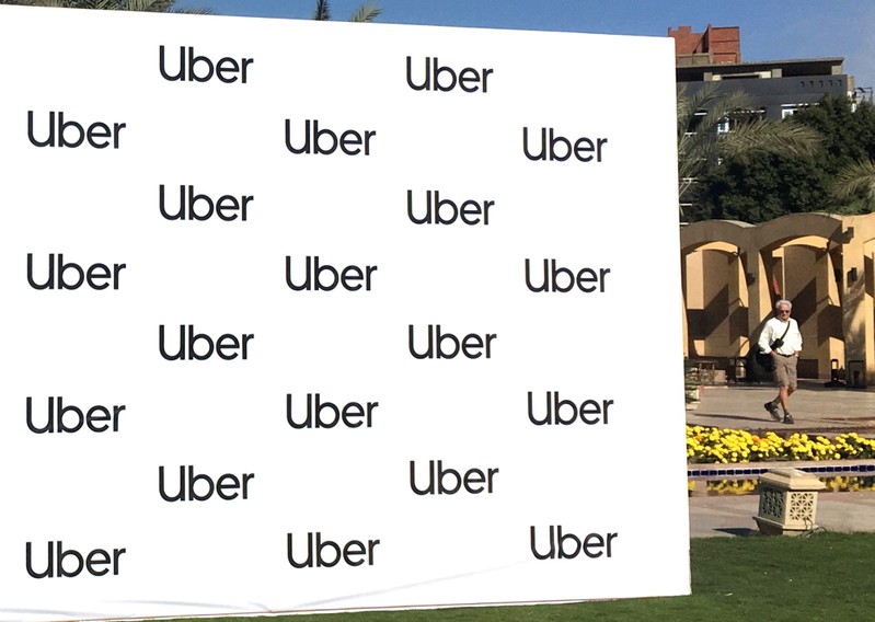 A man walks near a banner of ride-sharing app Uber during a news conference in Cairo