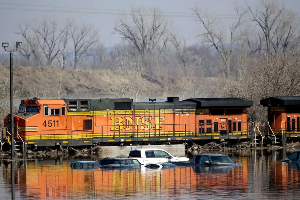 Cars sit in flood waters from the Platte River alongside a BNSF train, in Plattsmouth, Neb., March 17, 2019.