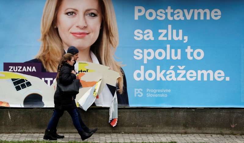 People walk past an election poster in Bratislava