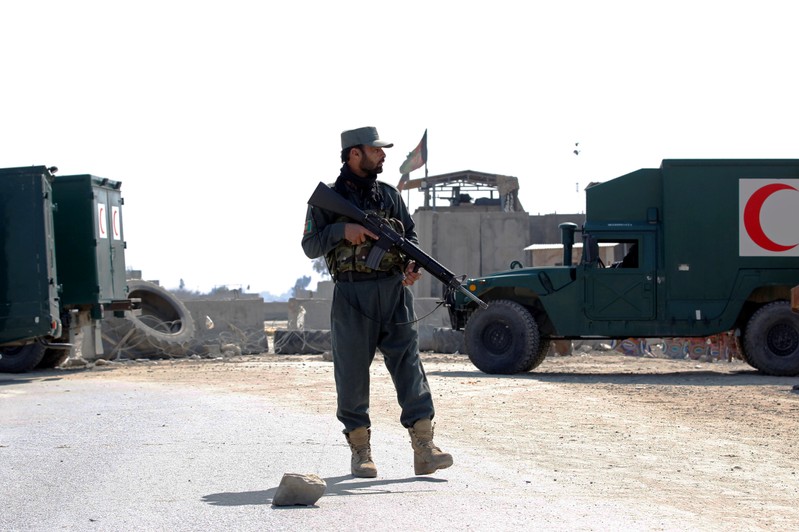 An Afghan police officer stands guard near the site of an attack in Jalalabad