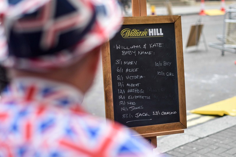 A man dressed in a Union Jack suit looks at the names and betting odds for the third royal baby of Britain's Prince William and Catherine, Duchess of Cambridge, on a board outside the Lindo Wing St Mary's Hospital in west London