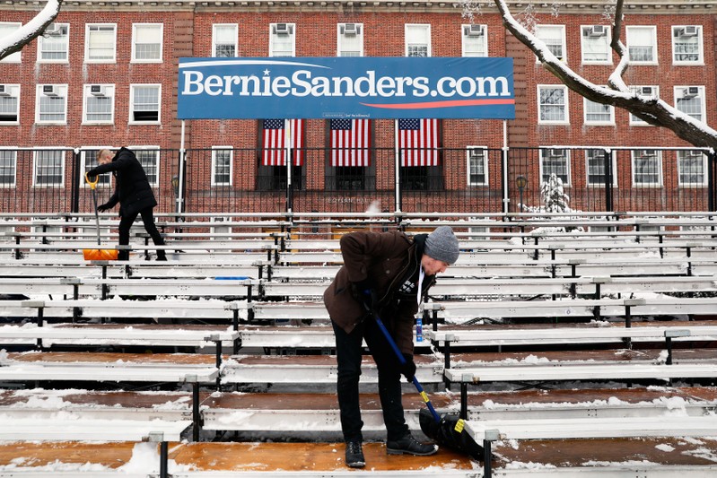 Workers clear bleachers of snow ahead of a rally by U.S. Presidential Candidate and Vermont Senator Bernie Sanders in New York