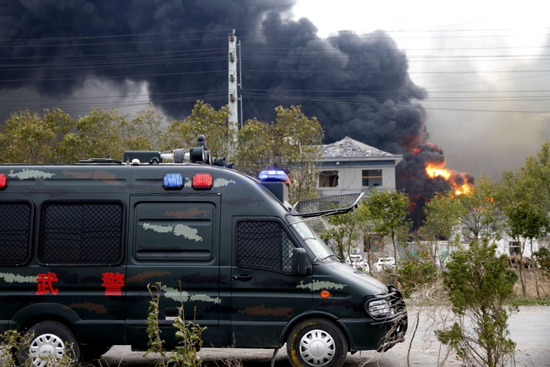 Vehicle of paramilitary police is seen near smoke following an explosion at a chemical industrial park in Xiangshui