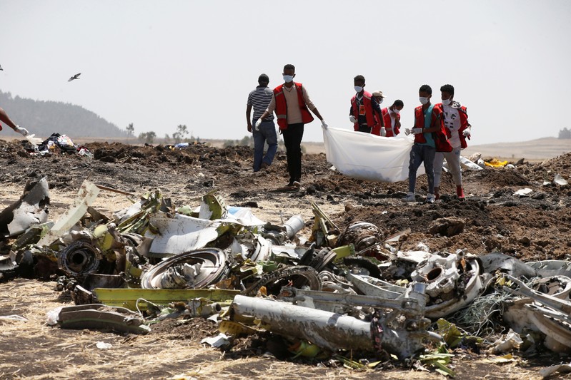 Ethiopian Red Cross workers carry a body bag with the remains of Ethiopian Airlines Flight ET 302 plane crash victims at the scene of a plane crash, near the town of Bishoftu, southeast of Addis Ababa