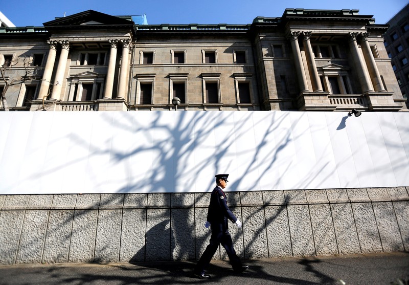 FILE PHOTO: A security guard walks past in front of the Bank of Japan headquarters in Tokyo