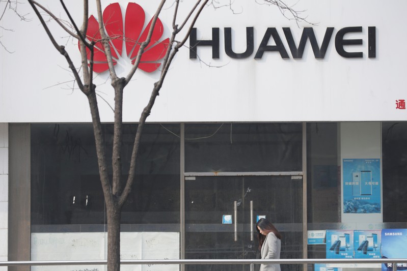 A woman walks past a Huawei store in Beijing