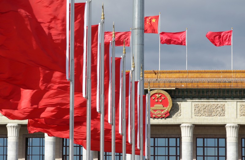 Red flags flutter in front of the Great Hall of the People in Beijing