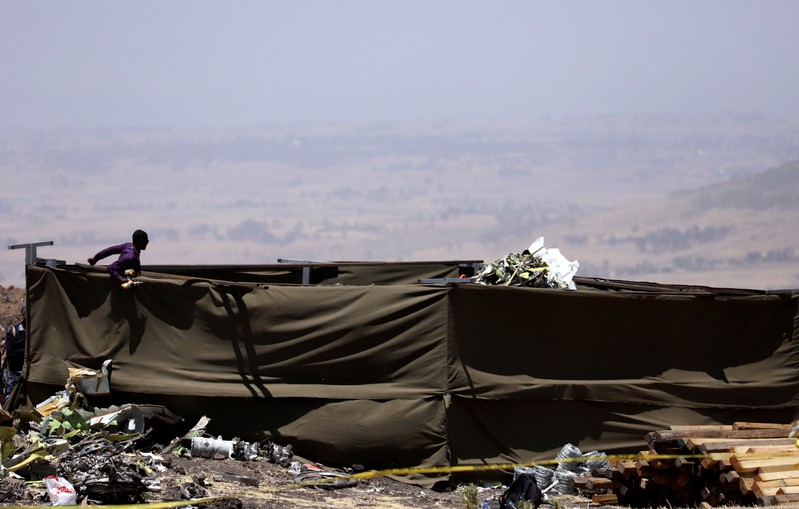 Member of a rescue team stands at the secured wreckage of the Ethiopian Airlines Flight ET 302 plane crash, near the town Bishoftu