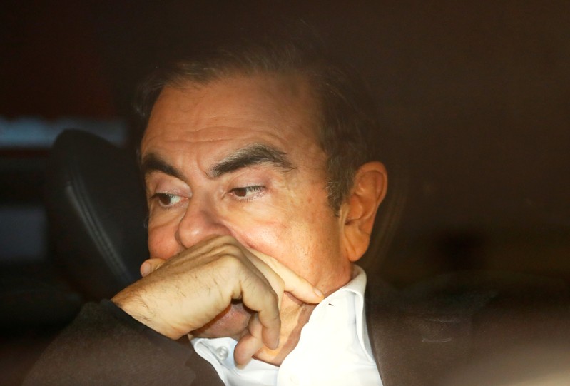FILE PHOTO : Former Nissan Motor Chairman Carlos Ghosn sits inside a car as he leaves his lawyer's office after being released on bail from Tokyo Detention House, in Tokyo