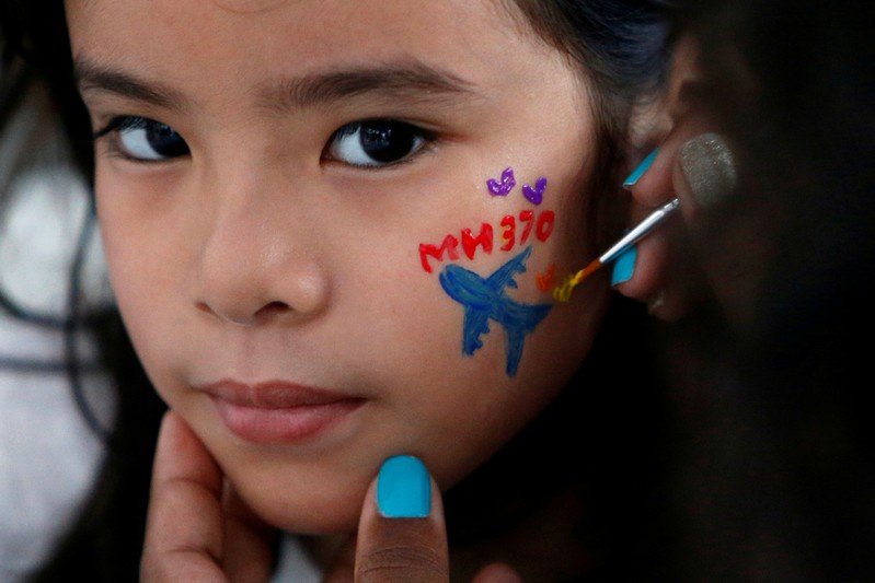 FILE PHOTO: Girl gets face painted during fourth annual remembrance event for missing MH370, in Kuala Lumpur