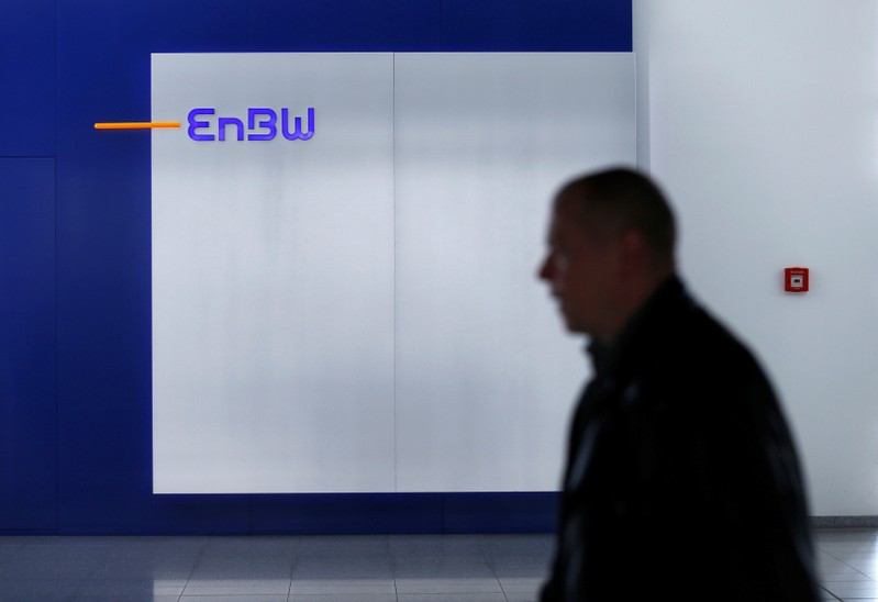 FILE PHOTO - A man walks past a logo of German power supplier EnBW Energie Baden-Wuertemberg AG in the companies headquarters in Karlsruhe