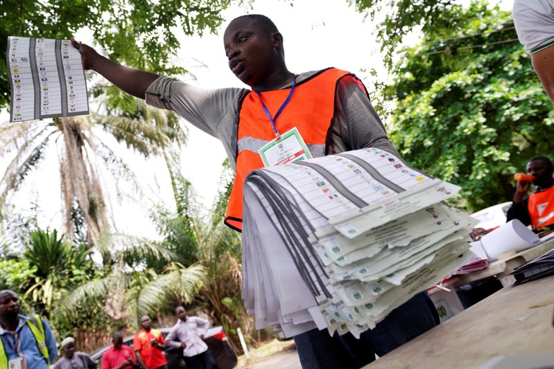 A man raises a ballot paper during the counting of governorship and state assembly election results in Lagos