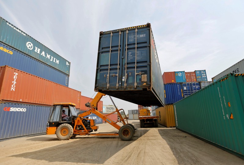 FILE PHOTO: A mobile crane carries a container at Thar Dry Port in Sanand in the western state of Gujarat, India
