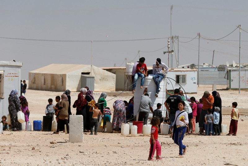 FILE PHOTO: Syrian refugees collect water at the Al-Zaatari refugee camp in Mafraq, Jordan, near the border with Syria