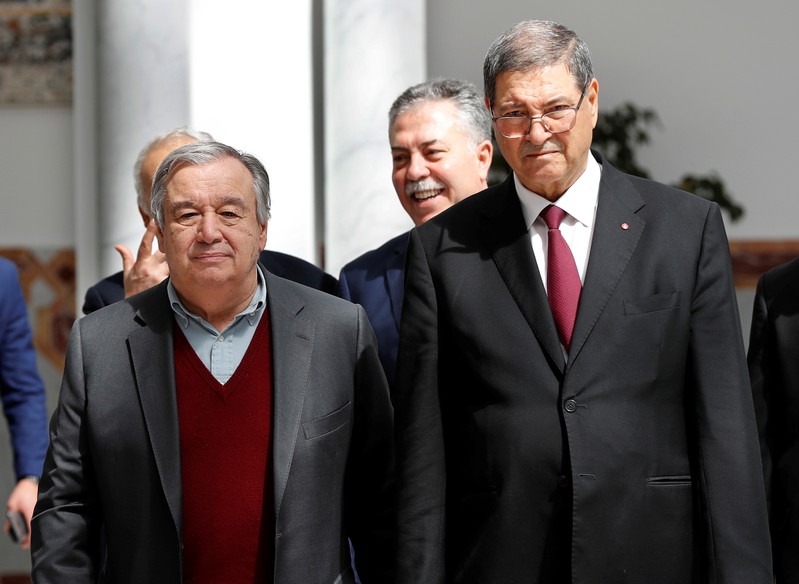 United Nations Secretary General Antonio Guterres walks next to the Tunisian Presidential Advisor for Political Affairs, Habib Essid, at Tunis-Carthage international airport, in Tunis