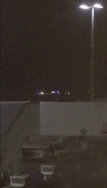 Emergency vehicles flash their lights in the distance at Stansted airport