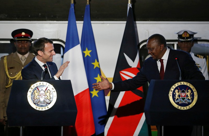 FILE PHOTO: French President Emmanuel Macron greets Kenya's President Uhuru Kenyatta as they address a news conference after touring the Nairobi Central Railway in Nairobi