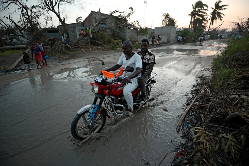 A motorcyclist rides through pools of water in the aftermath of Cyclone Idai in Beira