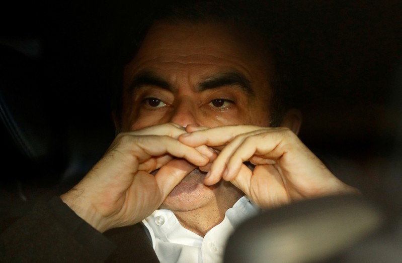 FILE PHOTO: Former Nissan Motor Chairman Carlos Ghosn sits inside the car as he leaves his lawyer's office after being released on bail from Tokyo Detention House, in Tokyo