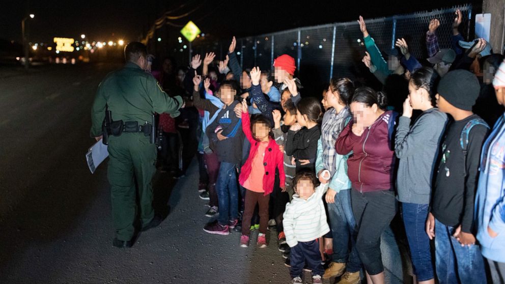 Migrants are seen lined up in El Paso, Texas, on March 23, 2019, after crossing the international border between the United States and Mexico and surrendering to a border patrol agent.
