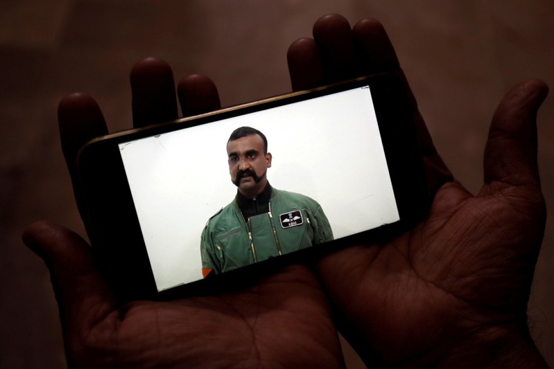 A man watches a statement of Indian Air Force pilot Abhinandan Varthaman on his mobile phone, released on Twitter by the Ministry of Information & Broadcasting, in Karachi