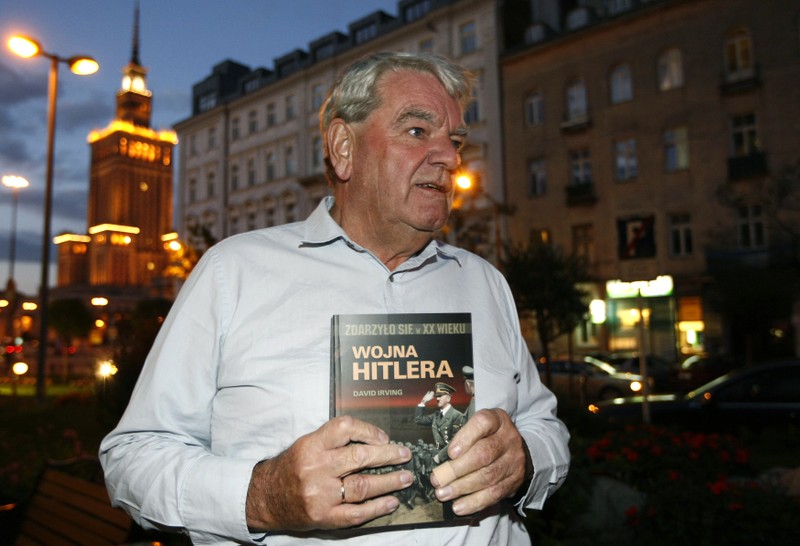 Irving, the British Holocaust-denier, holds his book as he speaks to Reuters during an interview in Warsaw