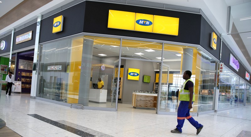 FILE PHOTO: A worker walks past an outlet of South Africa's MTN Group in Johannesburg, South Africa