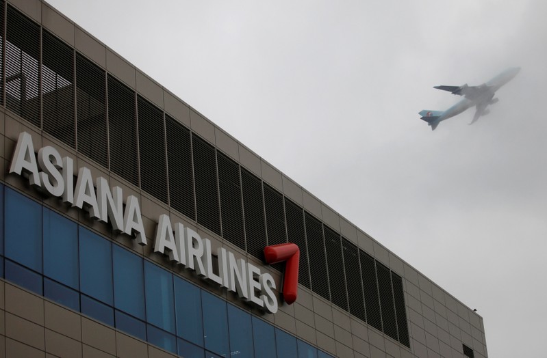FILE PHOTO: Aircraft flies over the head office of Asiana Airlines in Seoul